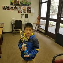 a little boy with a trophy posing for a picture