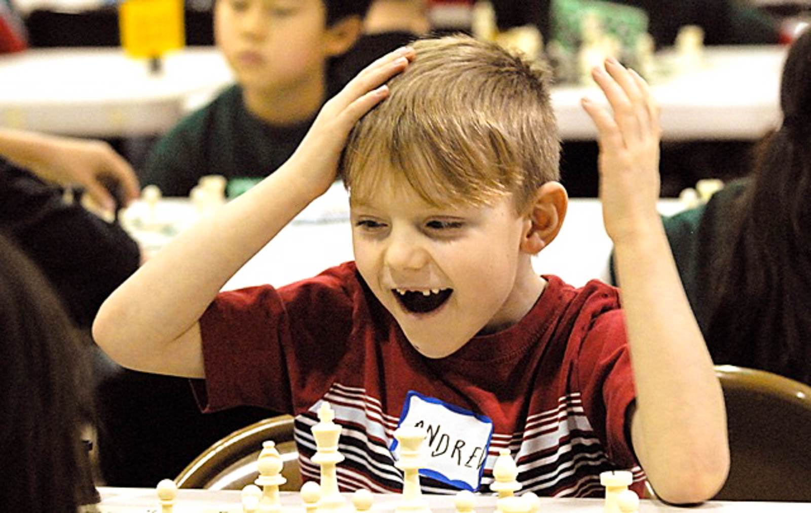 A child with broken teeth playing chess