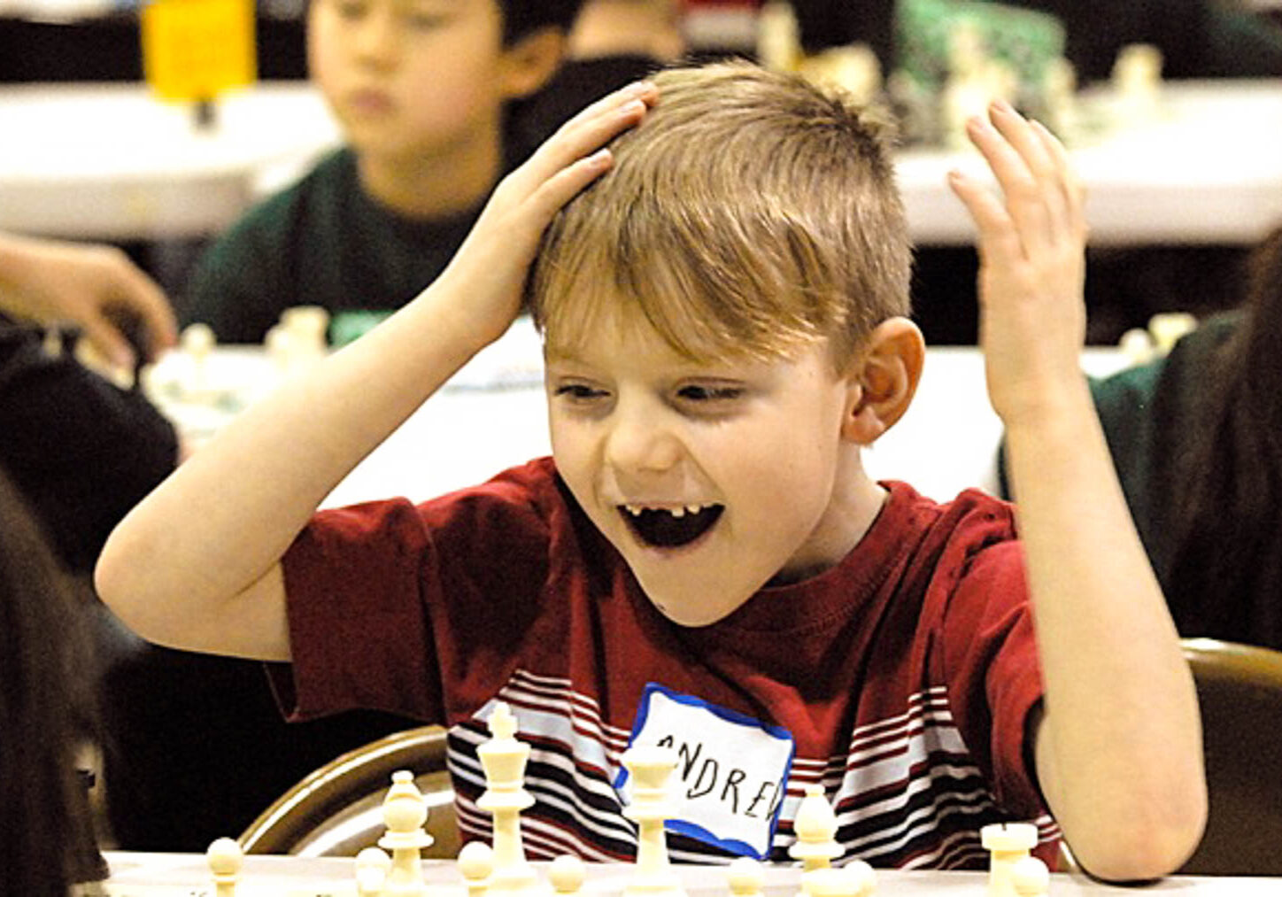 A child with broken teeth playing chess