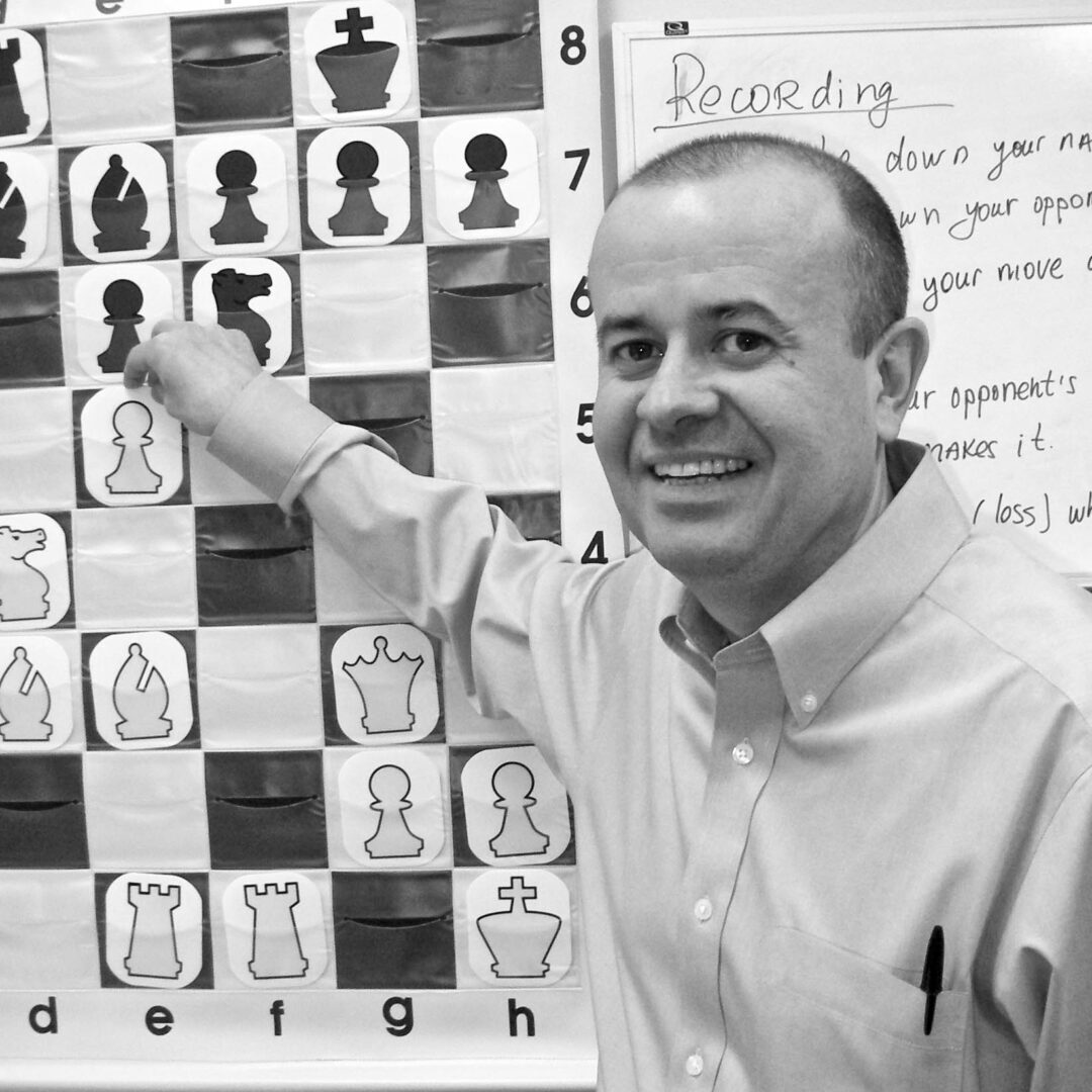 a man pointing out to a chess banner